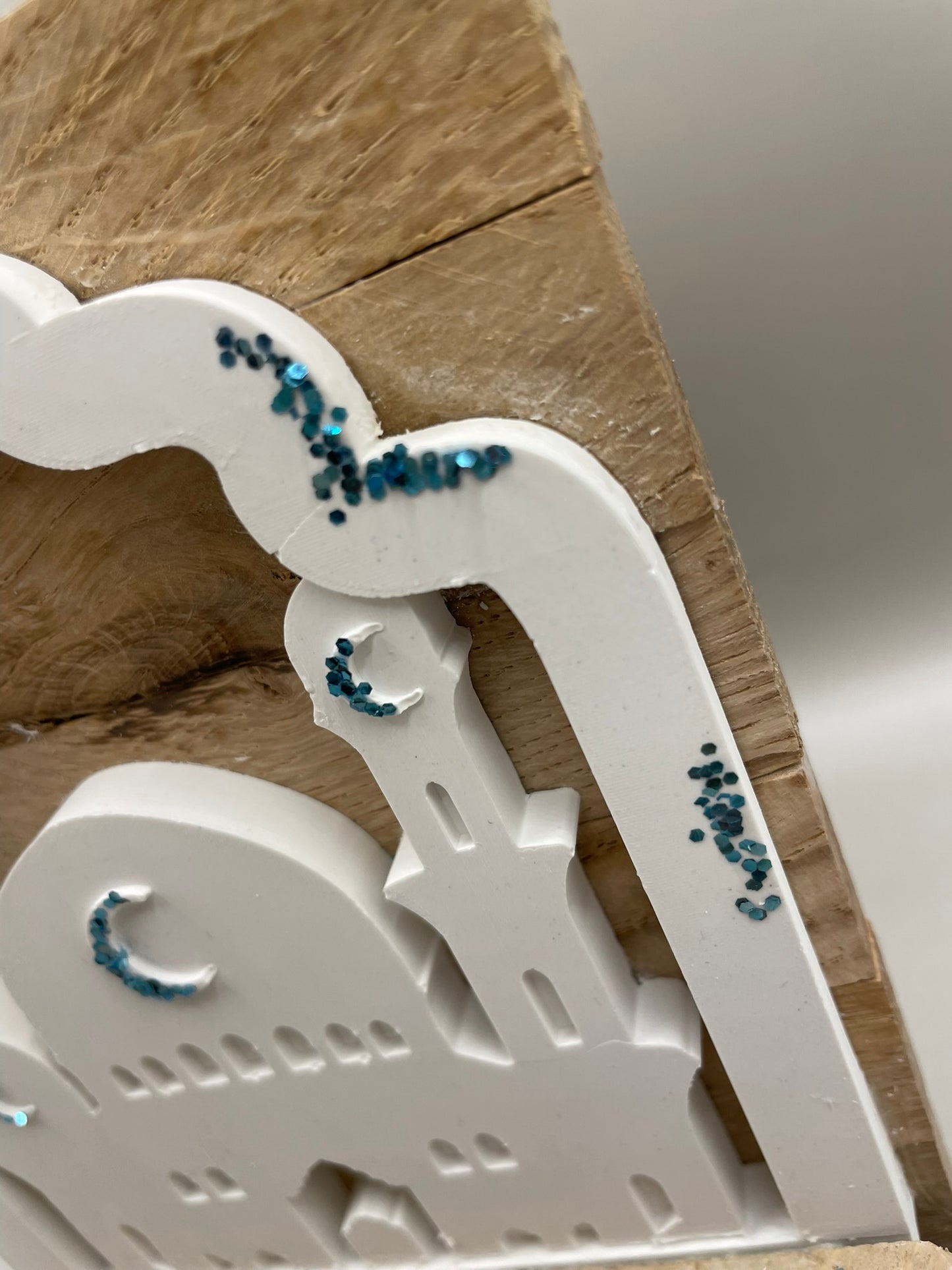 Geschenk in Form einer Mochee in weiß mit blauen Akzenten und der Überschrift "Bajram Mubarek" auf einem Holzgestellt